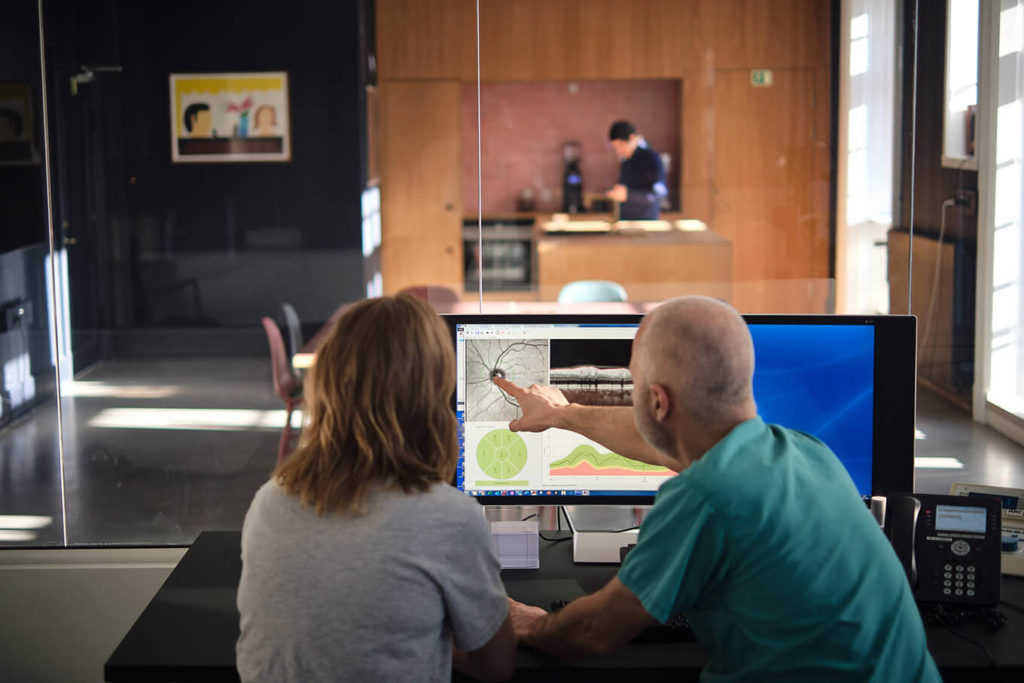 Øjenlæge eksaminerer billedresultat af patients øje hos Øjenlægerne på Rådhuspladsen.