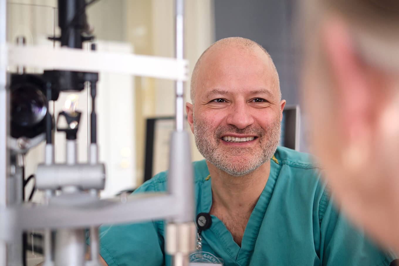 Øjenlæge smiler under undersøgelse af patient hos Øjenlægerne på Rådhuspladsen