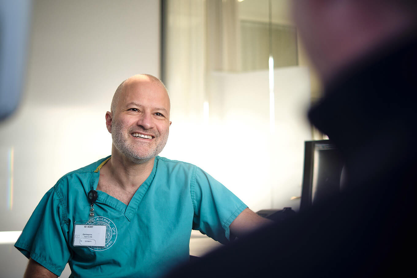 Øjenlæge smiler under undersøgelse af patient hos Øjenlægerne på Rådhuspladsen